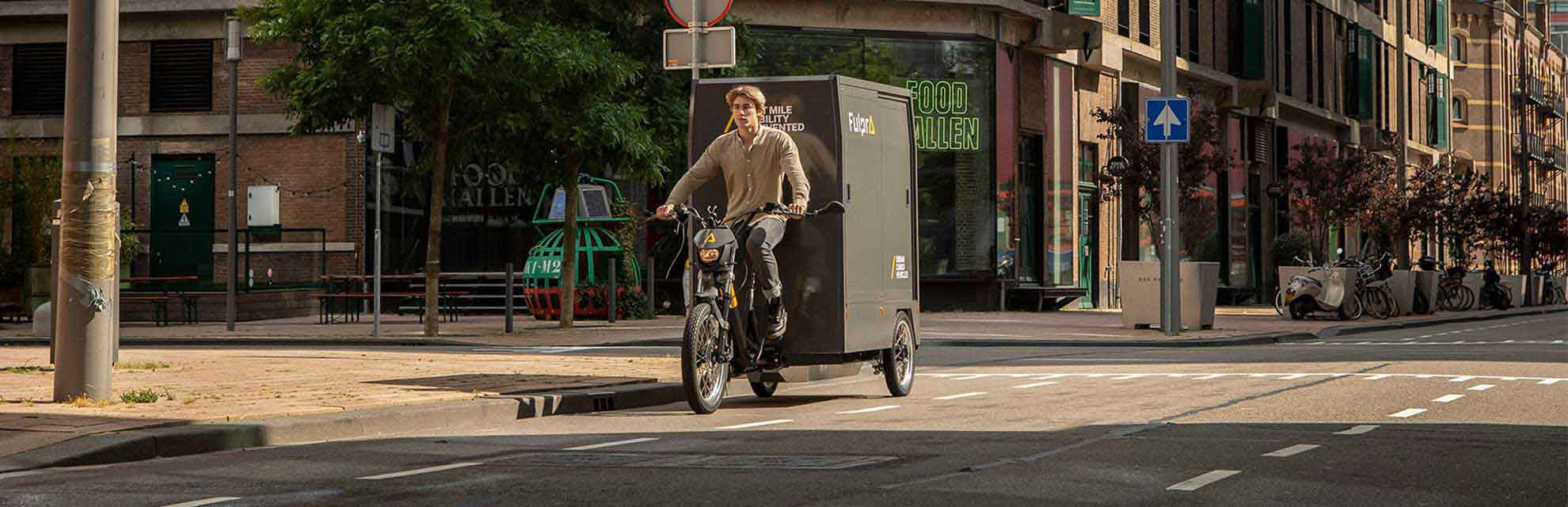 Fulpra Cargo-E-Bike fährt in der Stadt auf dem Radweg am Tag